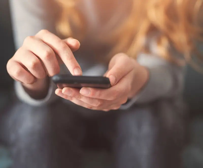 Image of a woman scrolling on her phone