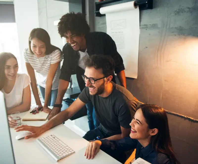 Image of a group of coworkers collaborating on a project at a computer