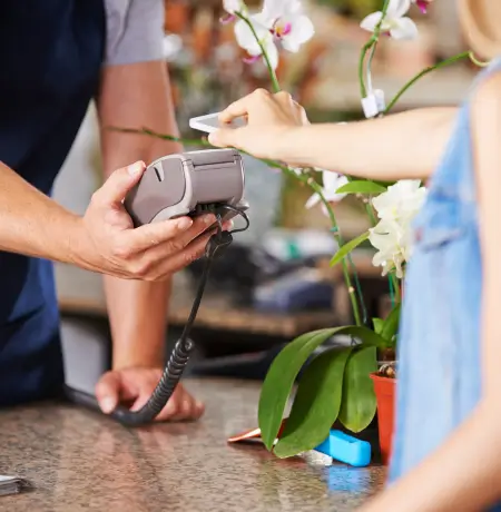 Image of a woman paying with her cellphone at a retail store