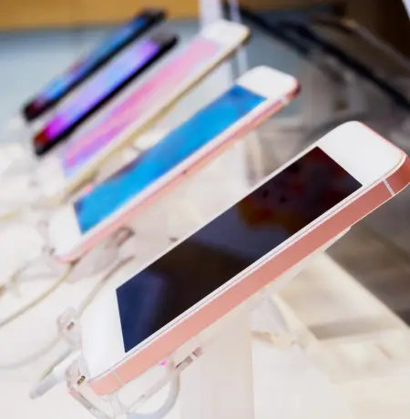 Image of 5 Iphones lined up in a retail store