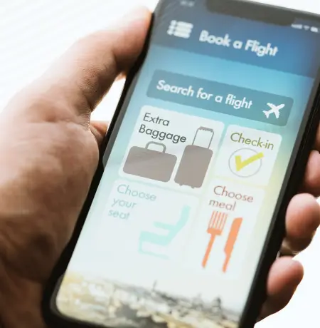 Image of a man holding a phone with a travel mobile app open