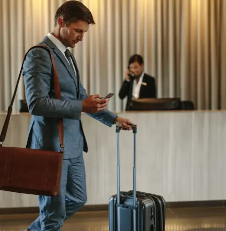 Image of a man in a hotel lobby checking his phone