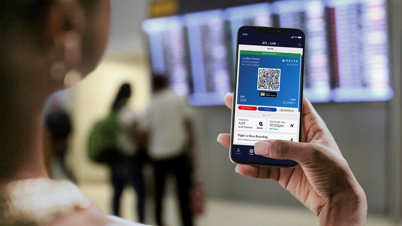 Image of a woman holding a phone with the Delta app open