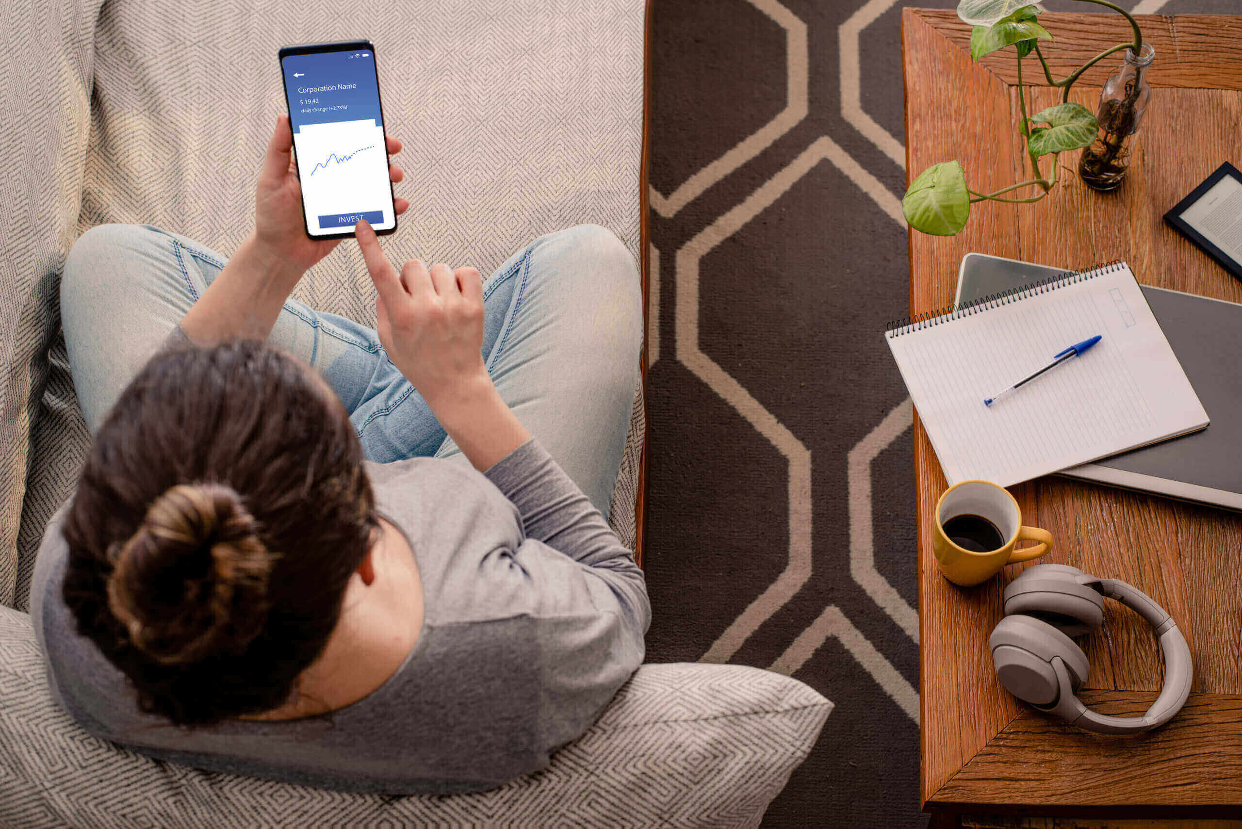 Image of a woman sitting on a couch using an app on her phone